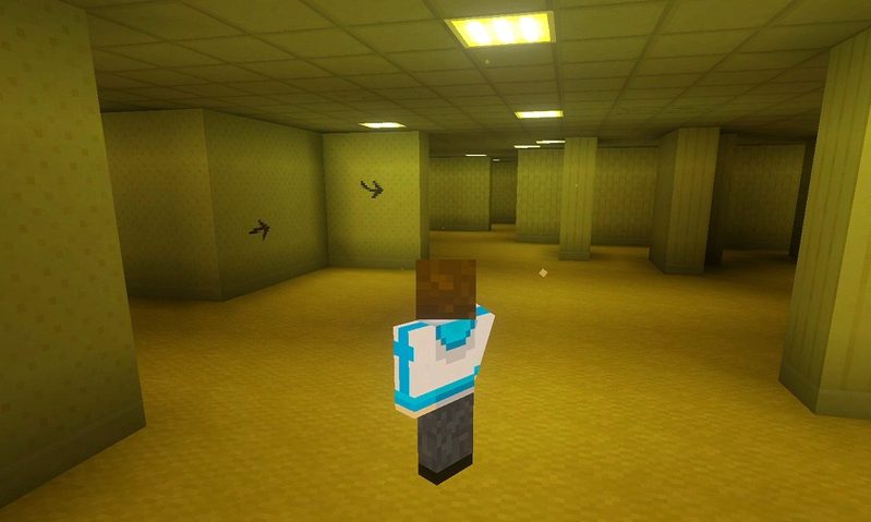 マイクラ統合版BACKROOMS Add-Onの黄色いロビーで、壁に黒い矢印が描かれている様子